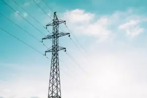 Électricien mesurant la tension en bout d'une longue ligne de câble alimentant un bâtiment annexe