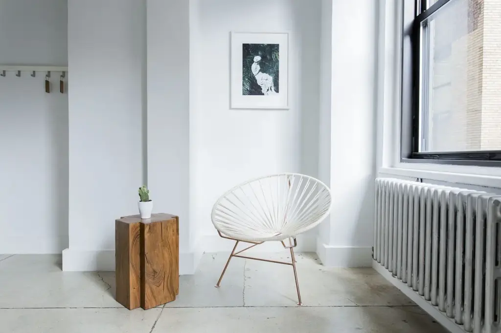 Électricien raccordant un radiateur électrique à inertie dans une pièce en rénovation