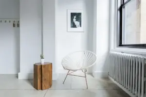 Électricien raccordant un radiateur électrique à inertie dans une pièce en rénovation