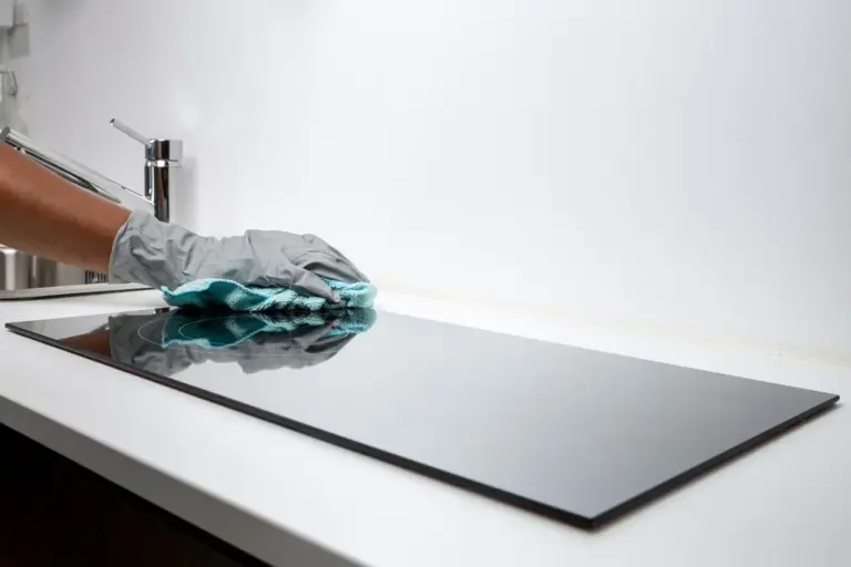 Électricien raccordant une plaque de cuisson à un bornier 32 A dans une cuisine en cours d'équipement