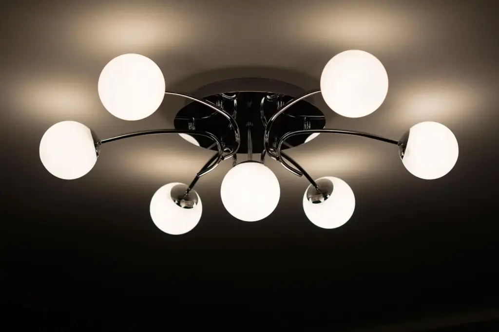 Électricien relevant les luminaires d'un plafond de bureau avant une rénovation en éclairage LED
