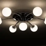 Électricien relevant les luminaires d'un plafond de bureau avant une rénovation en éclairage LED