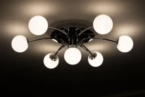 Électricien relevant les luminaires d'un plafond de bureau avant une rénovation en éclairage LED